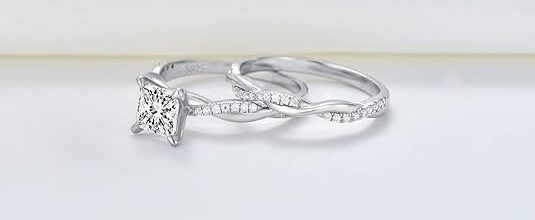 Princess cut wedding ring set for women featuring a 1-1/2 carat moissanite stone with a twisting infinity pave design in sterling silver, available in 10K, 14K, and 18K gold with free engraving option."